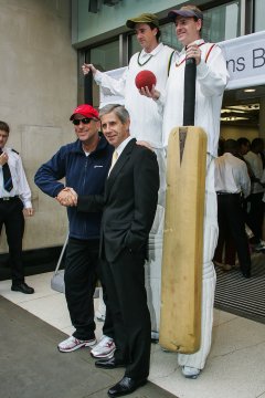 Cricketers on stilts with hugh cricket bat and ball, Beefy shaking hands in front